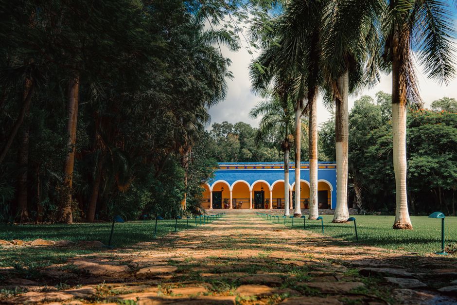 A vibrant colonial mansion framed by tall palm trees, ideal for tourism and architecture inspiration.